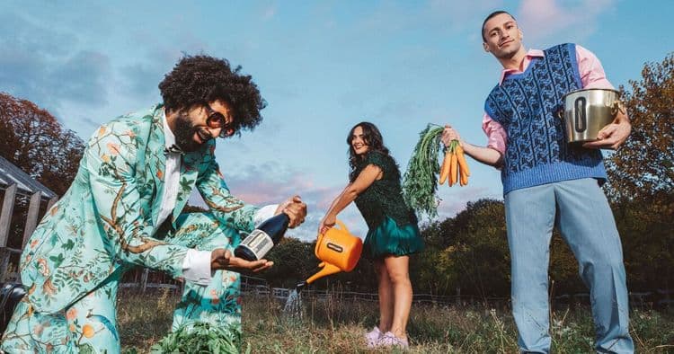 Kolonne Null Spaß Bild ein Mann mit Karotten im Strickpulli, einer, mit einem Afro in einem mintgrünen 70er-Jahre-Anzug, der eine Weinflasche hält, eine Frau gießt Blumen und im Hintergrund sieht man die violetten Wolken den Sonnenuntergang spiegeln.