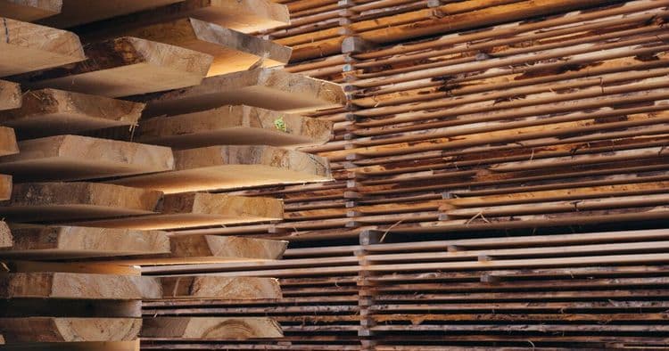 Sägewerk zugeschnittene Stammware zu hohen Stapeln aufgeschichtet